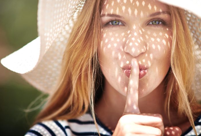 Woman Holding Finger to Mouth